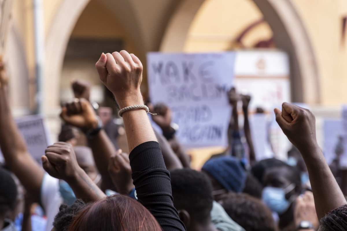 People raising fist with unfocused background in a pacifist protest against racism demanding justice