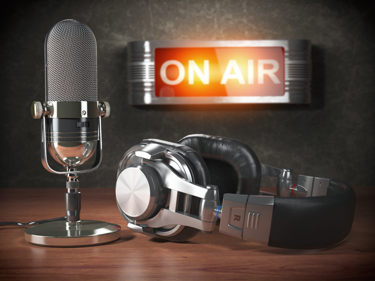 Vintage microphone and headphones with signboard on air. Broadcasting radio station concept. 3d illustration