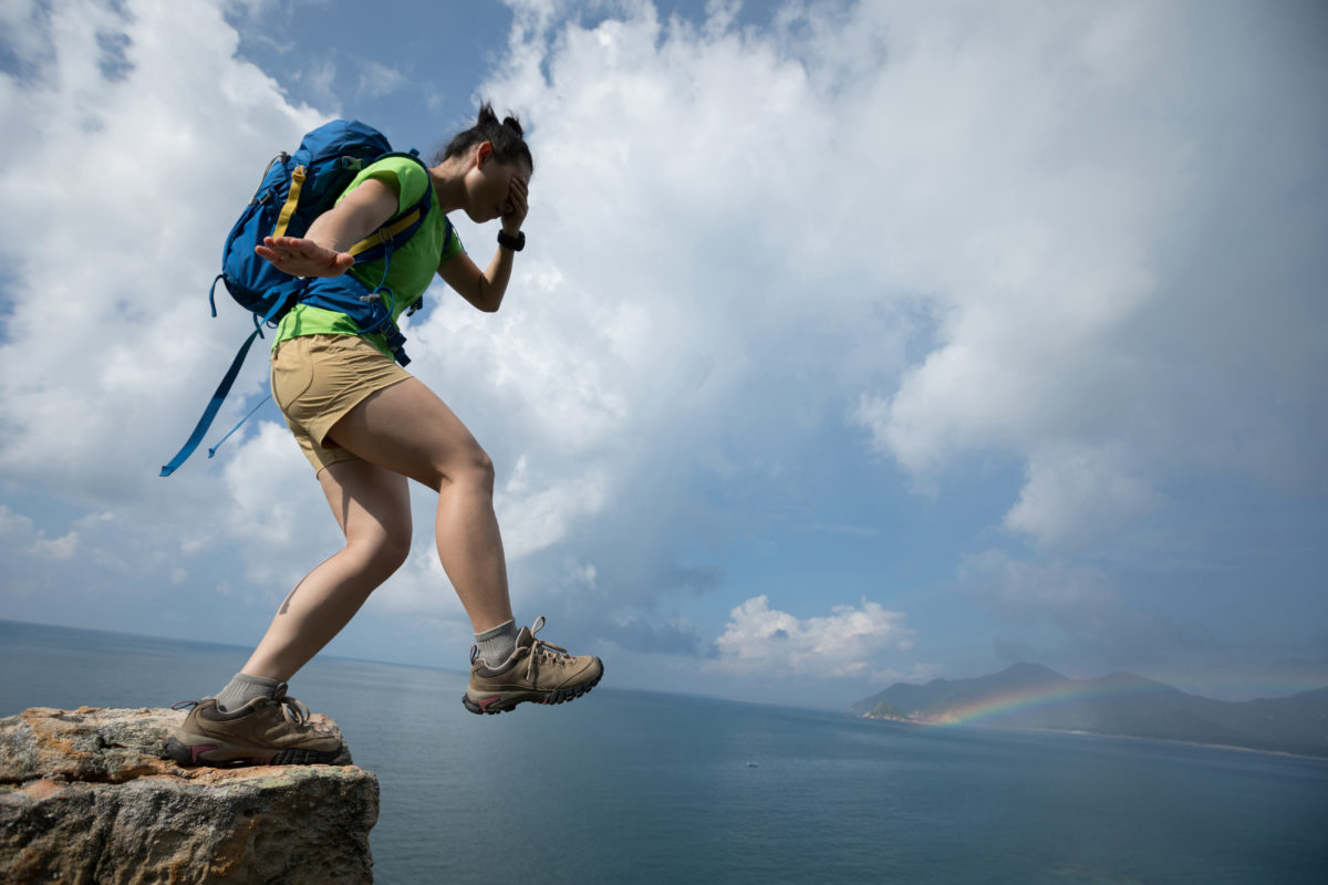 Woman walking off of a cliff with the eyes covered