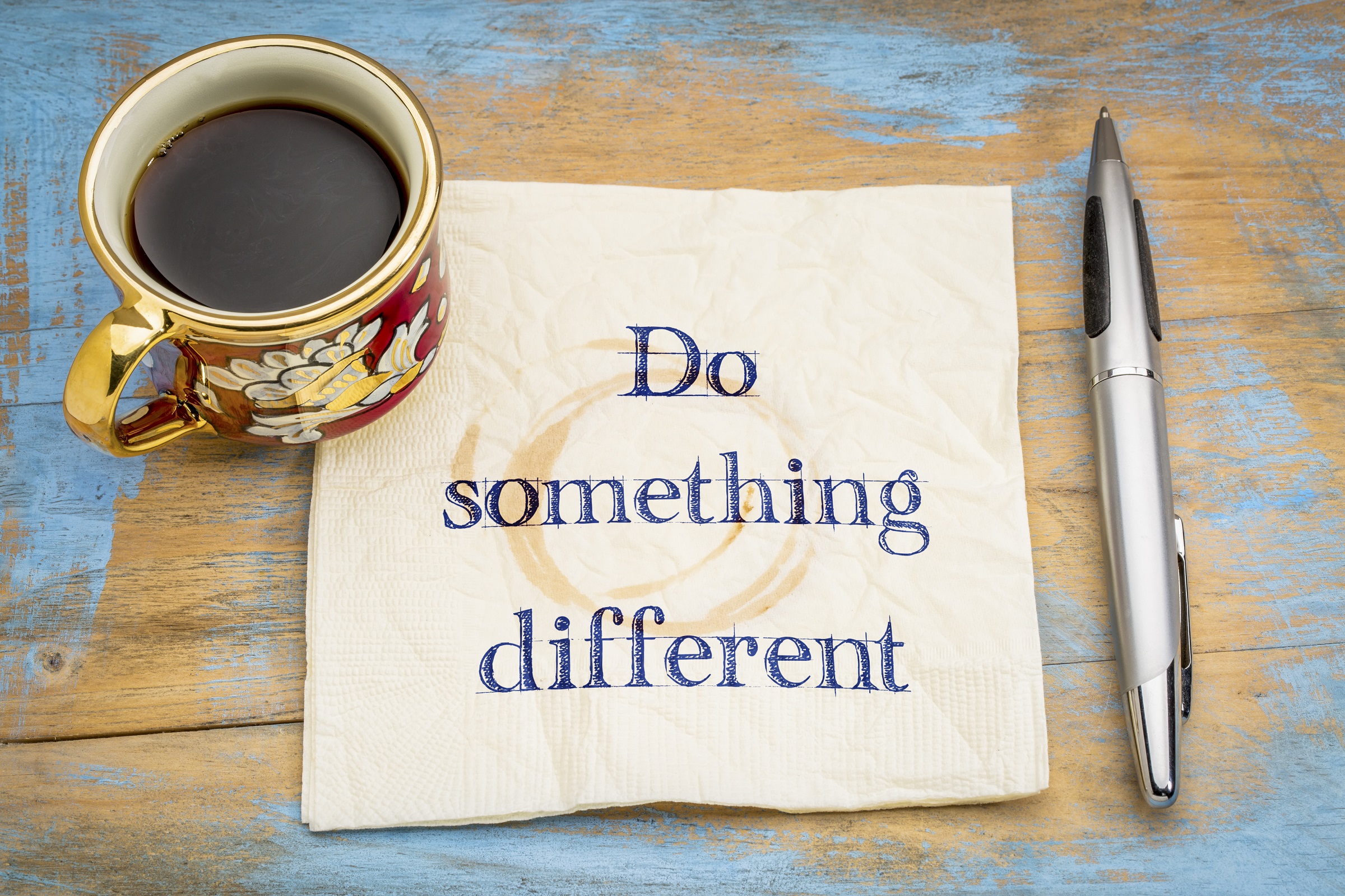 Do something different advice - handwriting on a napkin with a cup of coffee