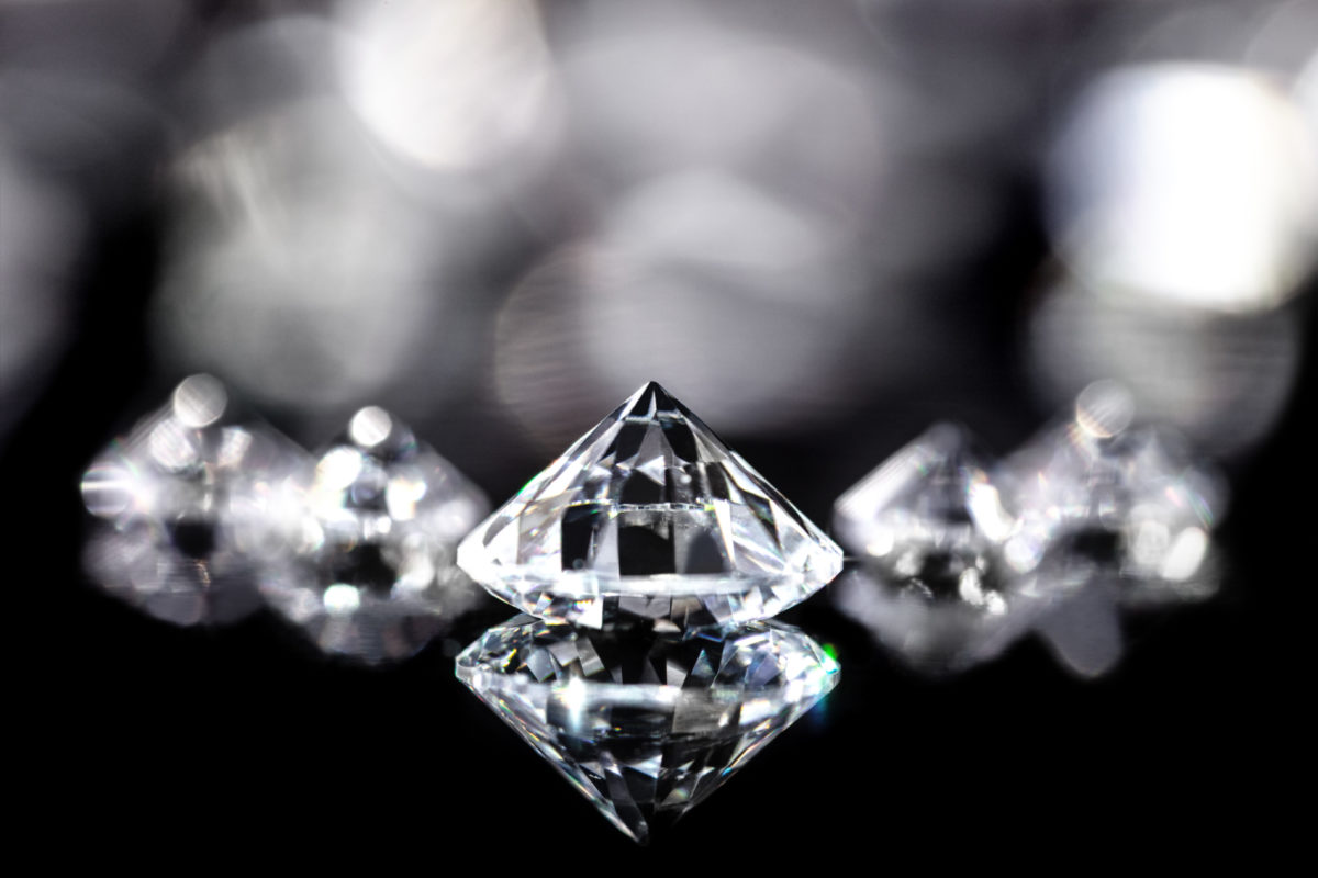 Diamanten im Brillantschliff vor schwarzem Hintergrund mit Reflextionen