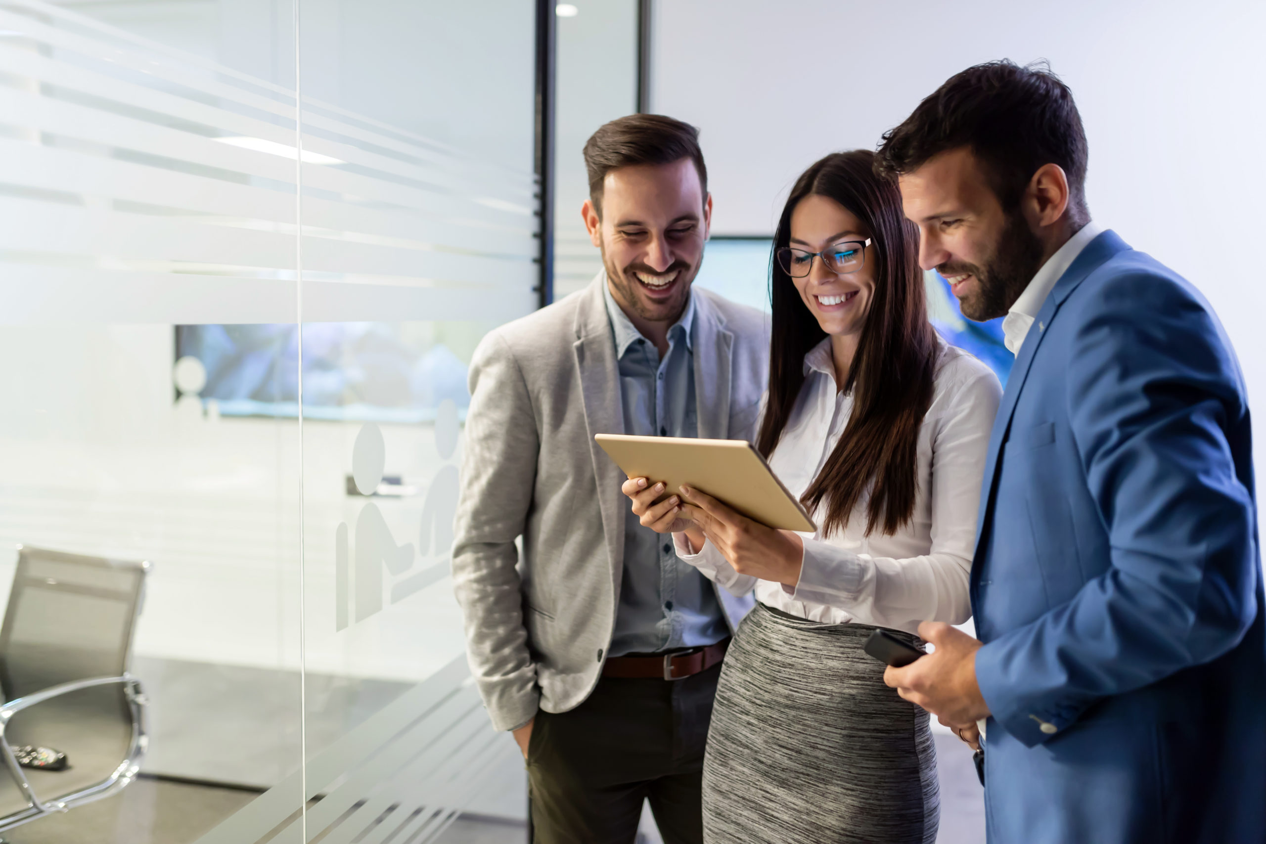 Businessmen and businesswoman using tablet in office