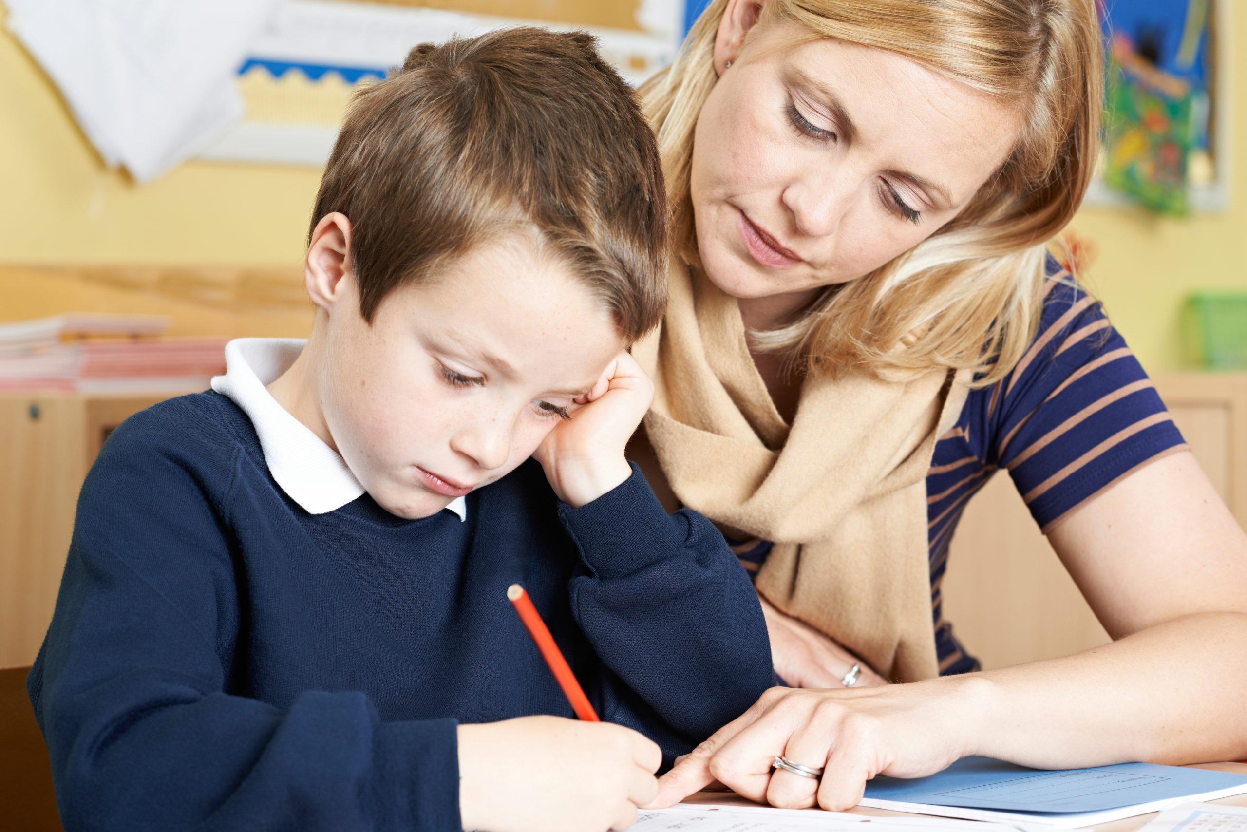 Teacher With Male Elementary School Pupil With Problem