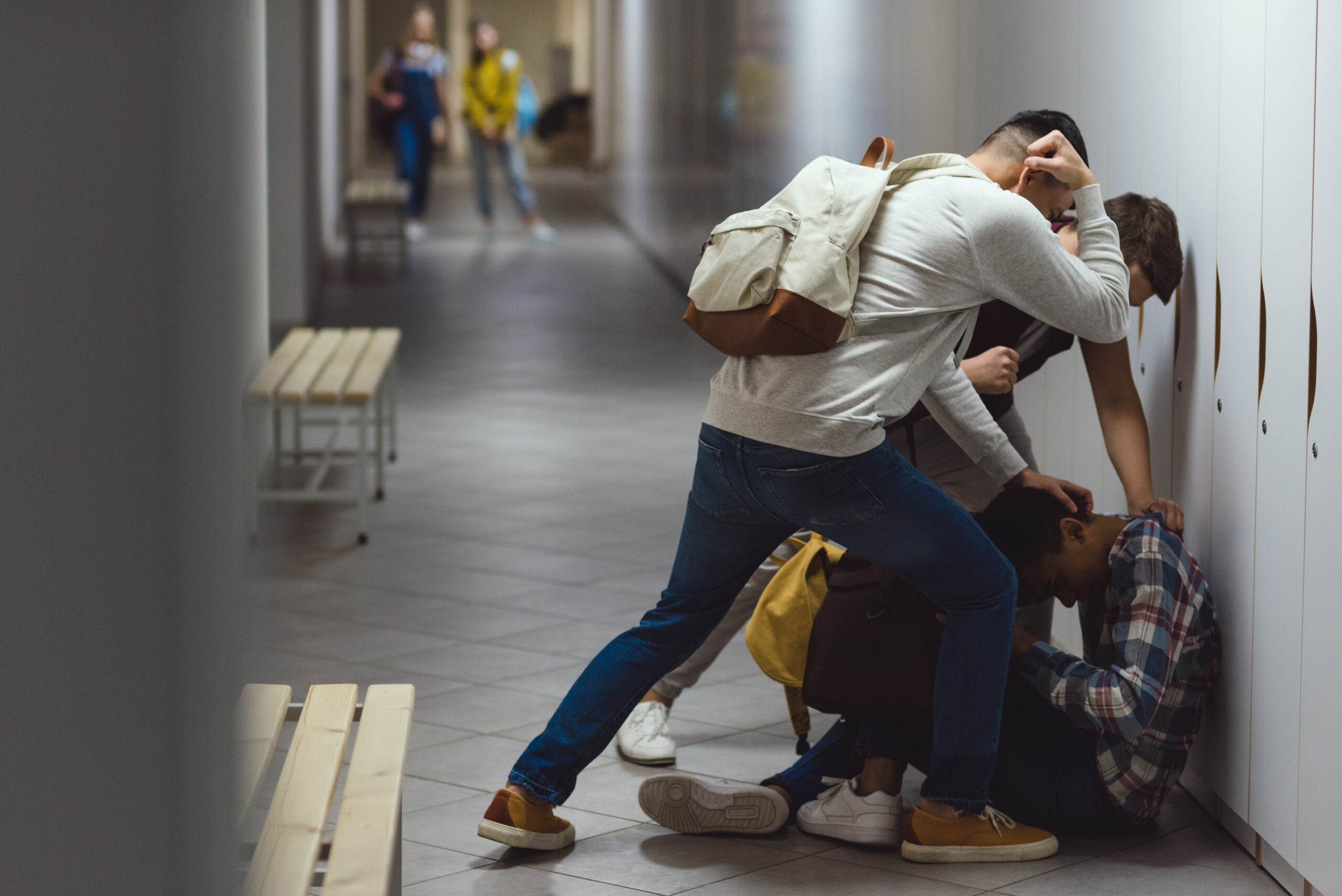 frightened african american schoolboy being bullied in school corridor