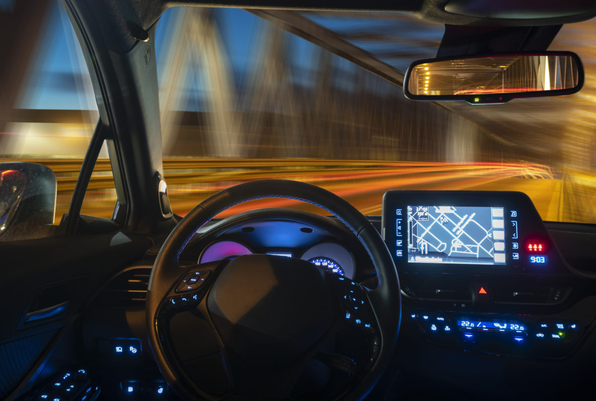 concept of the cockpit of an autonomous car driving at night illuminated by a tunnel